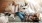 overhead view of  a woman texting as she lies on a couch with a dog at her feet